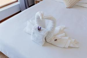 a towel swan sitting on a bed at Stompneus in Paternoster