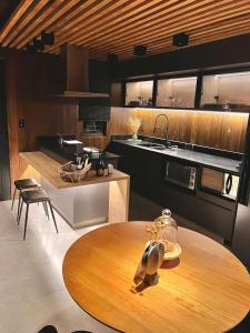 a kitchen with a wooden table in the middle of it at LUTS Chalés in Gonçalves +92 photos