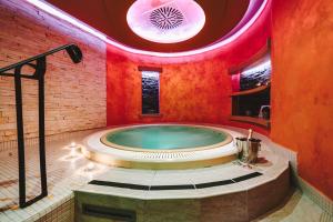 jacuzzi w pokoju z czerwonym sufitem w obiekcie Hotel Palcát w Taborze