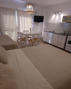 ein Wohnzimmer mit einem Tisch und einer Küche in der Unterkunft Munich Apart cdelu in Concepción del Uruguay