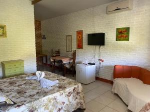 a room with two beds and a tv on the wall at La Dolce Vita in Mulungu