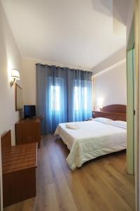 een slaapkamer met een groot bed en een houten vloer bij Hotel Laura in Rome