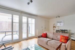 a living room with a couch and a glass table at Apartment Parking and terrace - 20 min from Paris in Maisons-Alfort