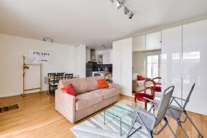 a living room with a couch and a table at Apartment Parking and terrace - 20 min from Paris in Maisons-Alfort