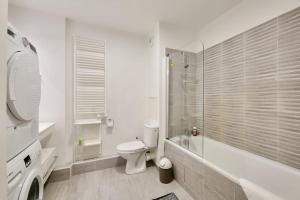 a white bathroom with a toilet and a shower at Apartment Parking and terrace - 20 min from Paris in Maisons-Alfort