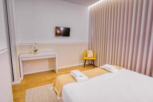 a bedroom with a bed and a table and a tv at Casa das Letras - Turismo rural in Ponte da Barca +34 photos