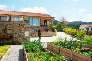 una casa con un jardín delante de ella en Casa das Letras - Turismo rural, en Ponte da Barca