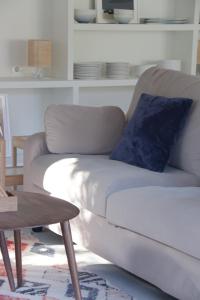 un sofá blanco en la sala de estar con una almohada azul en Casa Anida en Hualle, en Valdáliga