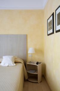um quarto com uma cama e uma mesa com um candeeiro em Hotel Colombia em Milão