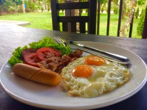 un plato de desayuno con huevos tocino y lechuga en The Retreat Khaolak Resort - SHA Extra Plus, en Khao Lak
