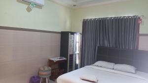 1 dormitorio con cama blanca y ventana en CALDERA PARK HOMESTAY Syariah, en Probolinggo