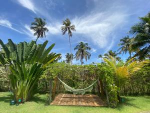 a hammock in a garden with palm trees at Kasa Karapató in Pôrto de Pedras