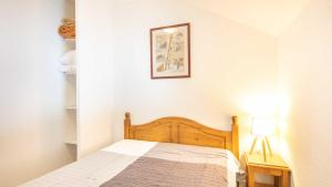 - une chambre avec un lit et une lampe sur une table dans l'établissement Les Marmottes - 42 - Appart renove - 6 pers, à Saint-Sorlin-dʼArves