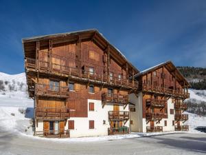 聖索林達爾沃的住宿－Les Marmottes - 42 - Appart renove - 6 pers，一座大木结构建筑,在雪中设有阳台
