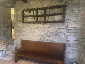 un banco de madera sentado contra una pared de piedra en Mas Sabaters - L'Era de Sabaters en Tavernoles