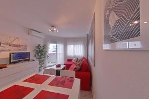 sala de estar con sofá rojo y TV en Tranquilo , soleado cerca de la playa, en Torremolinos
