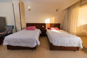 duas camas num quarto de hotel sem ermott em Palma Resort Hurghda em Hurghada