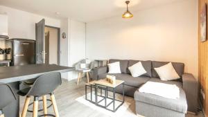 ein Wohnzimmer mit einem Sofa und einem Tisch in der Unterkunft Les Grizzlis - 28 - Appart modernise - 4 pers in Saint-Sorlin-dʼArves