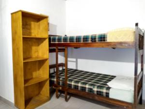 1 dormitorio con 2 literas y estante para libros en Hosteria Las Piedras en Puerto Iguazú