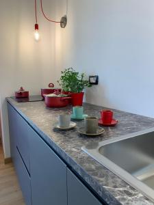 un bancone della cucina con ciotole, tazze e lavandino di Guest House Mela a Lecce Altre 35 foto