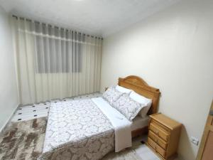 um quarto com uma cama, uma cômoda e uma janela em City Centre Apartment - New Deco em Tânger