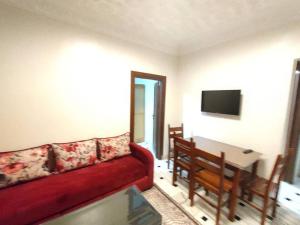 uma sala de estar com um sofá vermelho e uma mesa em City Centre Apartment - New Deco em Tânger