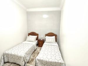 duas camas em um quarto com paredes brancas em City Centre Apartment - New Deco em Tânger mais 9 fotografias