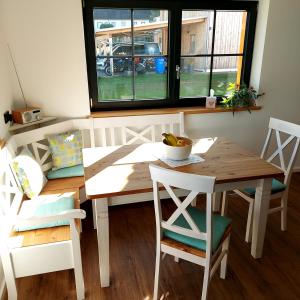 comedor con mesa, sillas y ventana en Ferienwohnung Familie Roth, en Rückholz