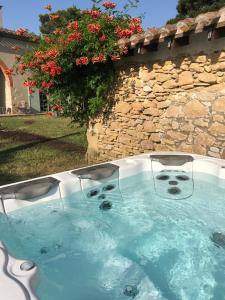 una bañera de hidromasaje en un patio junto a una pared de piedra en 5 Bedroom Villa, La Bastide d'Anjou, Occitanie en Airoux