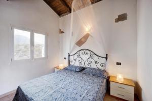a white bedroom with a bed and a window at L'angolo del Mare in Pompeiana