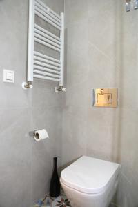 La salle de bains est pourvue de toilettes blanches et d'un vase. dans l'établissement Piso Moderno a 2 minutos del Casco Viejo con Parking Gratis, à Bilbao