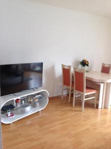 un soggiorno con tavolo, sedie e TV di Sonnenschein a Baden-Baden