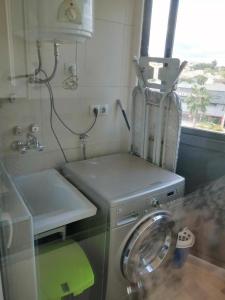 una cucina con lavatrice e lavandino di Apartamento Pepe a Alcantarilla