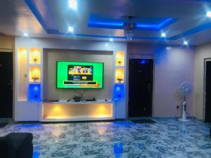 Pokój z telewizorem z płaskim ekranem na ścianie w obiekcie Umbrella properties - Eleyele Ibadan w mieście Ibadan