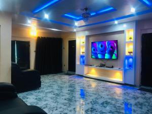 uma sala de estar com uma televisão de ecrã plano na parede em Umbrella properties - Eleyele Ibadan em Ibadan