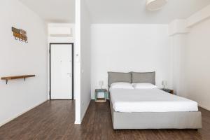 a white bedroom with a white bed and a mirror at Largo Molina Studio II by Wonderful Italy in Bologna