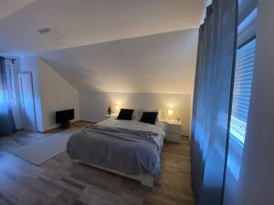 a bedroom with a bed in a white room at Vikendica Fruskogorski kutak in Krušedol