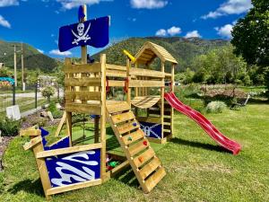a wooden playset with a slide and a playground at Apartmánový dom Adas in Prosiek
