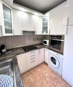 a kitchen with white cabinets and a washer and dryer at Star Apartments with free parking in Budapest