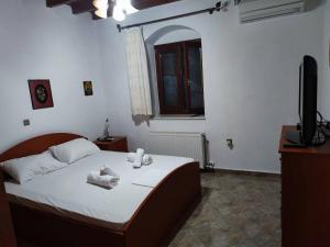 una camera da letto con un letto e asciugamani di Πέτρινο Εξοχικό Σπίτι στη Σύρο a Firókambos