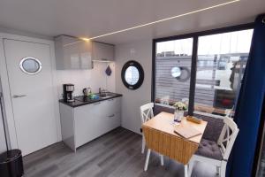 a small kitchen and dining room with a table and chairs at Hausboot Fjord Aquila mit Dachterrasse in Wendtorf in Wendtorf