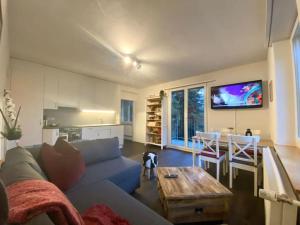 uma sala de estar com um sofá azul e uma mesa em Beautiful flat with nice lake and mountain views em Weggis