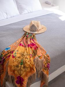 a hat and a dress on a bed at BlackRock suites in Karterados