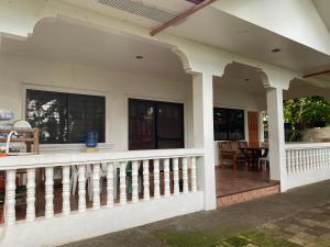 een veranda aan de voorzijde van een huis met een leuning bij Villa Juana in Panglao