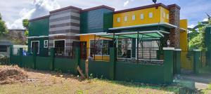 een gebouw met een groen hek ervoor bij Tourist and Transient HOME. in Sorsogon