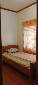niewielka sypialnia z łóżkiem i oknem w obiekcie Tourist and Transient HOME. w mieście Sorsogon