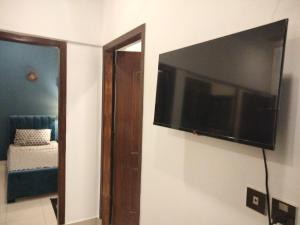 einen Flachbild-TV an der Wand eines Zimmers in der Unterkunft The Realtors Inn 2 BDR Apartment in Islamabad