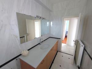 a white bathroom with a sink and a mirror at Greek Aesthetic Manor House in Nea Makri