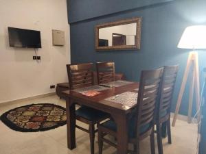 ein Esszimmer mit einem Tisch, Stühlen und einem Spiegel in der Unterkunft The Realtors Inn 2 BDR Apartment in Islamabad