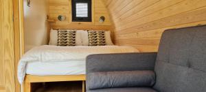 a small bedroom with a bed and a chair at Habberley Glamping Pods in Shrewsbury
